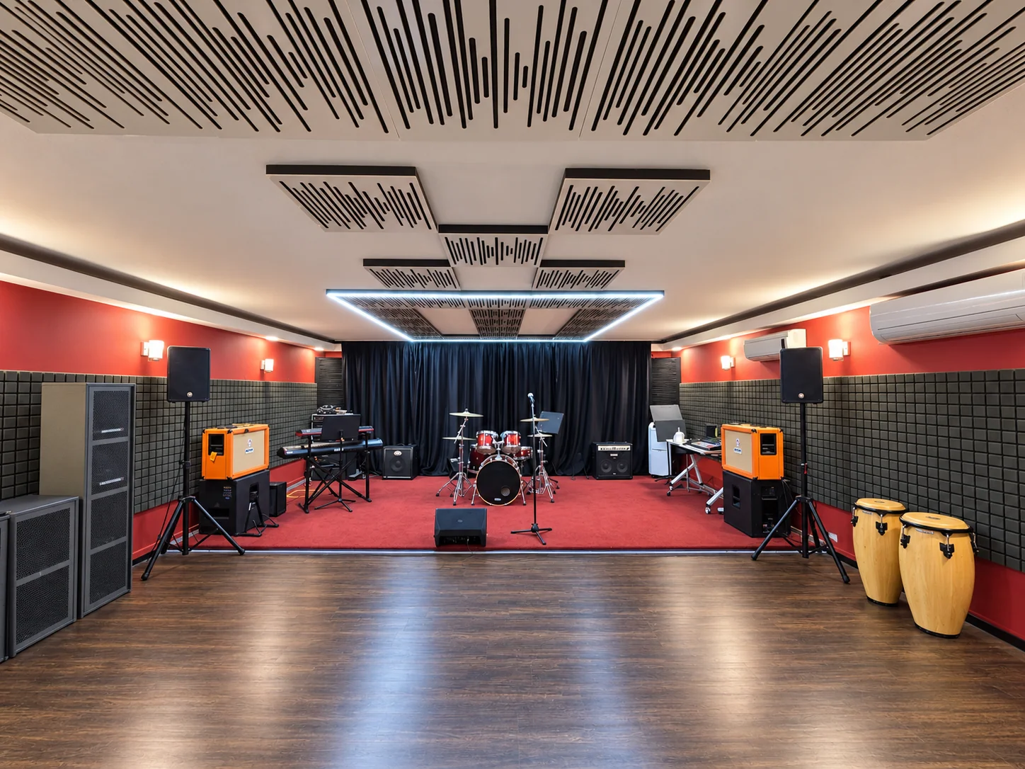 AOR jamming and rehearsal studio with a drum kit, keyboards, amplifiers, speakers and percussion