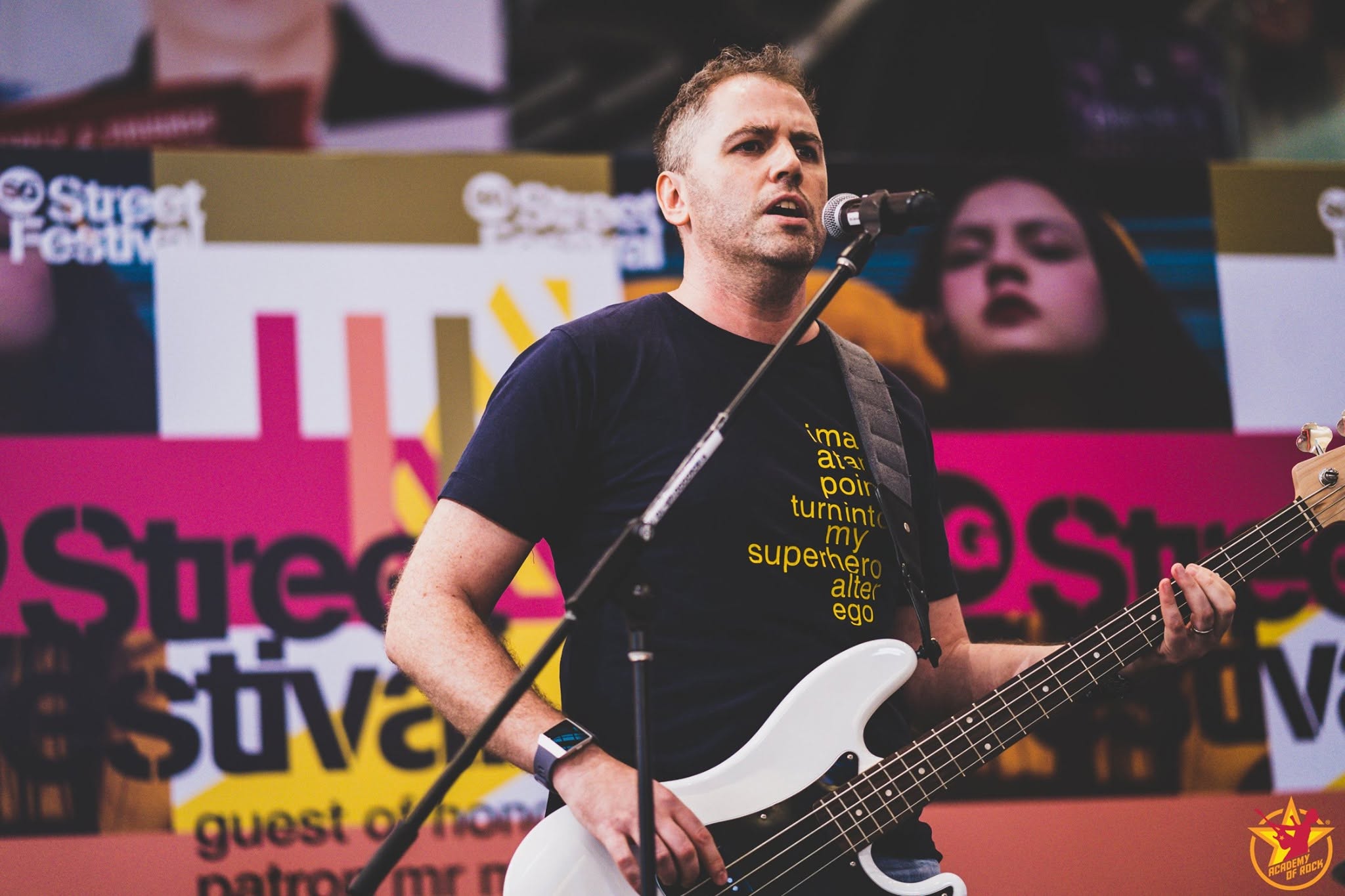 Singer performing on stage with a band.
