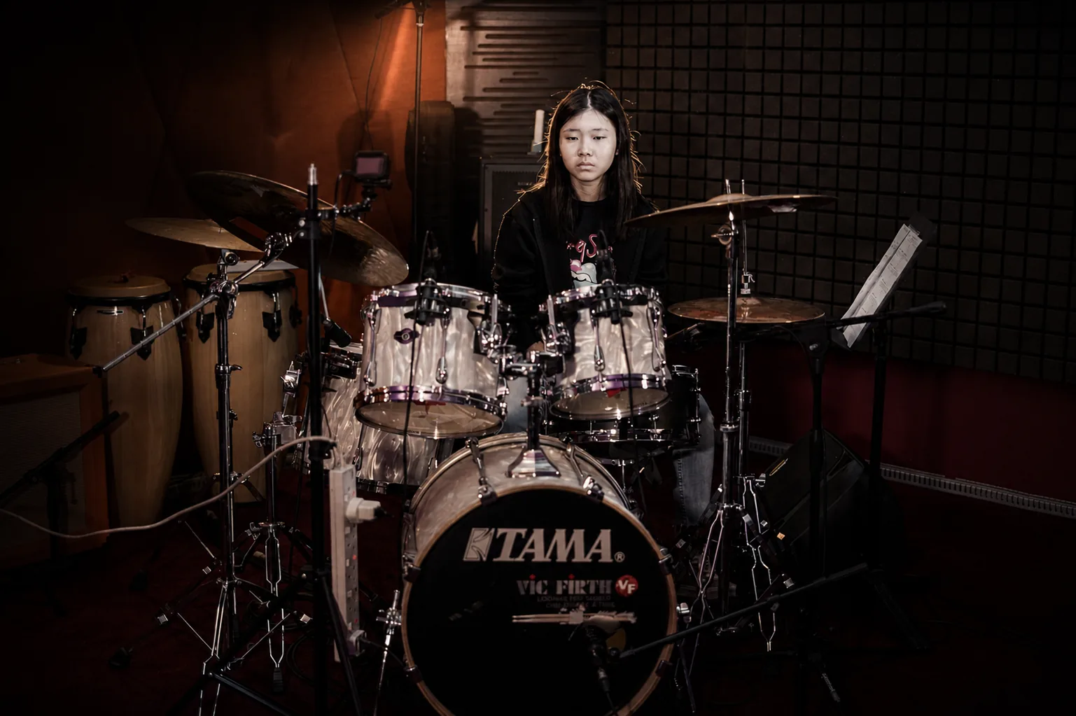 Person seated at a drum kit.