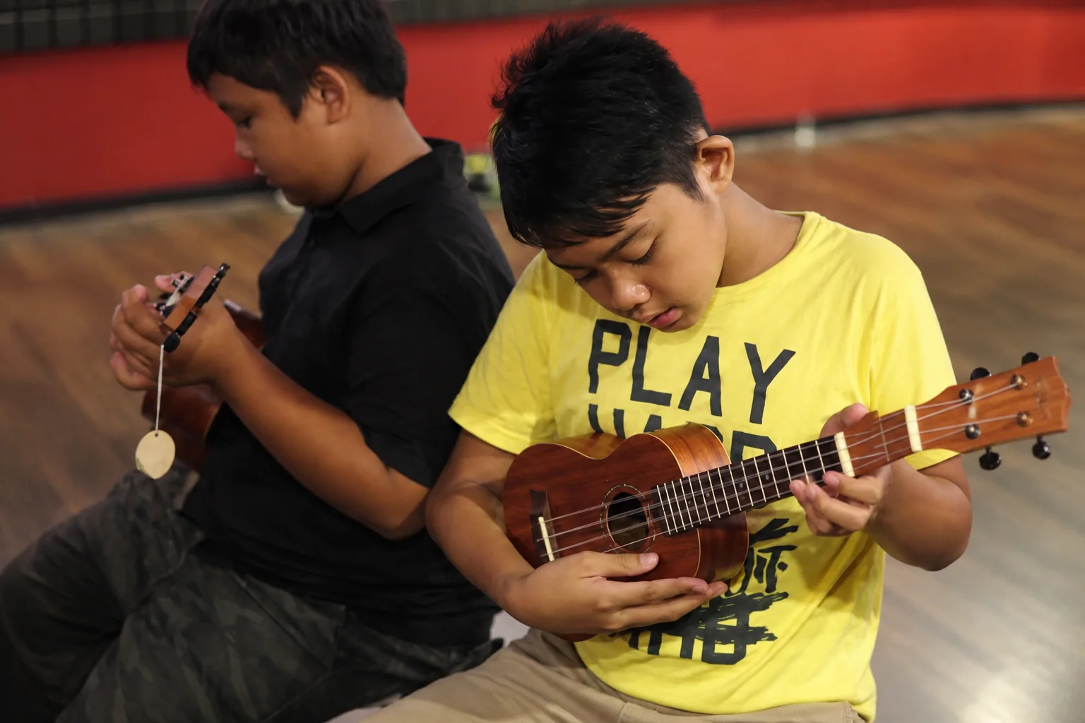 Two young people holding ukuleles.